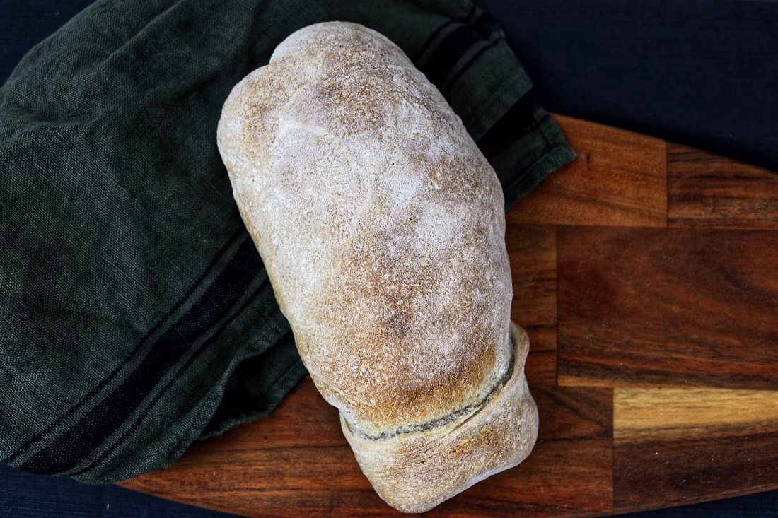 Bola de pão de Mafra inteira, numa tábua de madeira